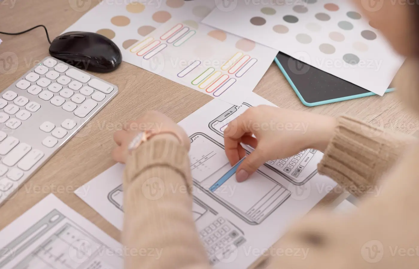 A designer discussing app planning materials on a table